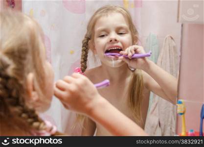 Five-year girl brushing her teeth in the bathroom