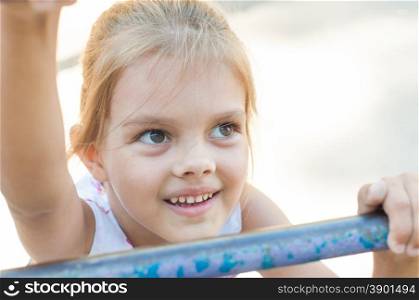 Five-year girl climbs the ladder on playground. Five-year girl playing on the playground climbs the stairs