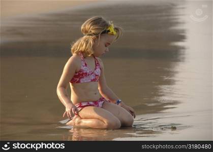 Five year old girl playing in sand