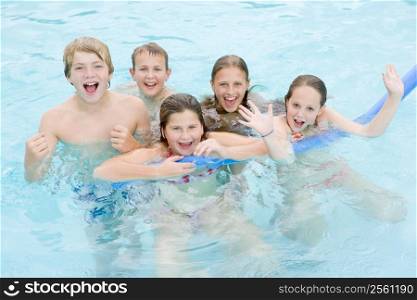 Five young friends in swimming pool playing and smiling