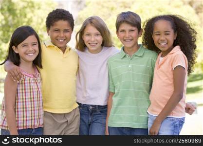 Five young friends standing outdoors smiling