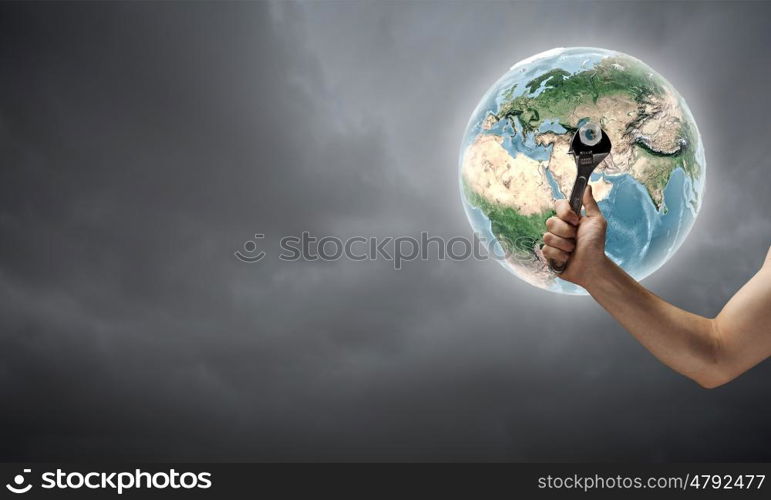 Fixing planet problem. Close up of hand spinning nut on Earth planet. Elements of this image are furnished by NASA