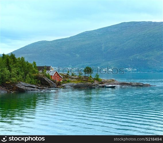 Fjord summer cloudy view with wooden house on coast (Norway)