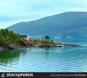 Fjord summer cloudy view with wooden house on coast (Norway)