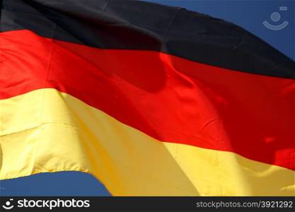 Flag of Germany with wrinkles and seams expanded in the breeze