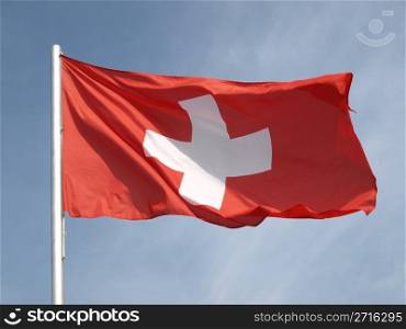Flag of Switzerland over a blue sky. Flag of Switzerland
