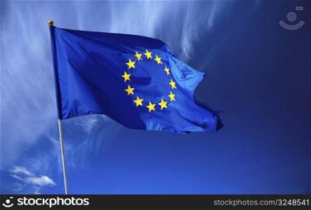 Flag of the european union in front of the deep blue sky.