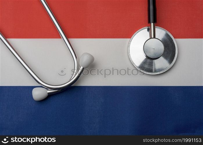 Flag of the Netherlands and stethoscope. The concept of medicine. Stethoscope on the flag in the background.. Flag of the Netherlands and stethoscope. The concept of medicine.