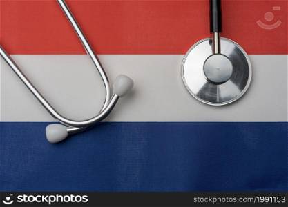 Flag of the Netherlands and stethoscope. The concept of medicine. Stethoscope on the flag in the background.. Flag of the Netherlands and stethoscope. The concept of medicine.