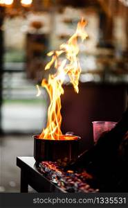 flames in a frying pan. A professional chef produces flames for food. Chef cooking with open fire pan. fire cooking show. selective focus. flames in a frying pan. A professional chef produces flames for food. Chef cooking with open fire pan. fire cooking show. selective focus.