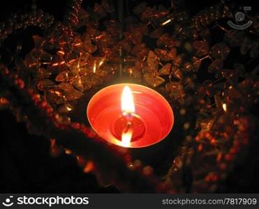 Flaming candle in basket and dark background