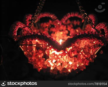 Flaming candle in basket and dark background