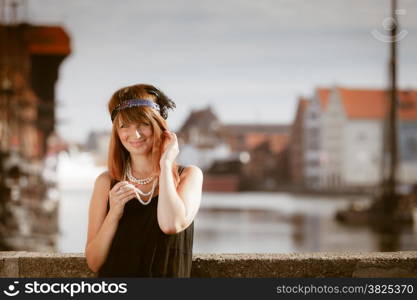 Flapper girl. Retro style fashion vintage woman from roaring 1920s outdoor on the street. Old town Gdansk Danzig in the background