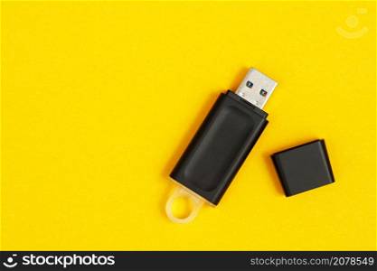 Flash drive for data storage placed on a yellow background