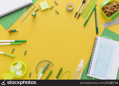 flat lay back school materials with notebook face mask