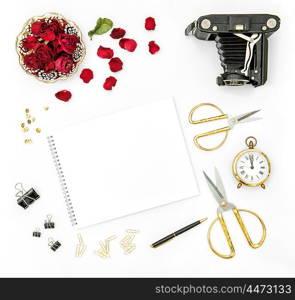 Flat lay background with red roses flowers, vintage photo camera and golden accessories