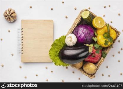 flat lay basket fresh vegetables with notebook