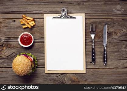 flat lay burger with mock up clipboard