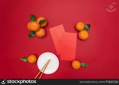 Flat lay Chinese lunar new year traditional food and offering red envelope on table top
