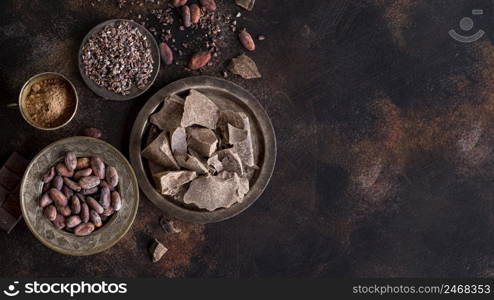 flat lay chocolate chunks plate with cocoa beans powder copy space