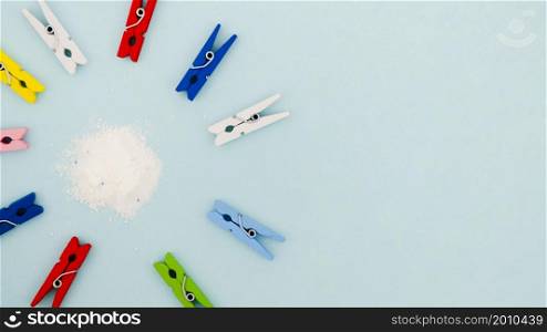 flat lay colorful clothes pins surrounding detergent