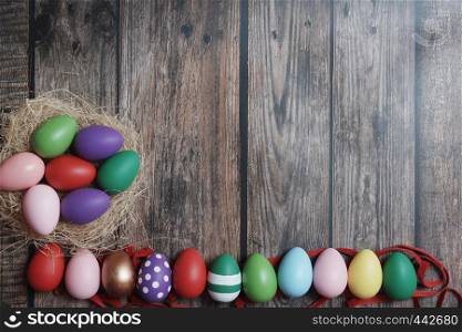 Flat-lay colorful Easter eggs on wooden table copy-space