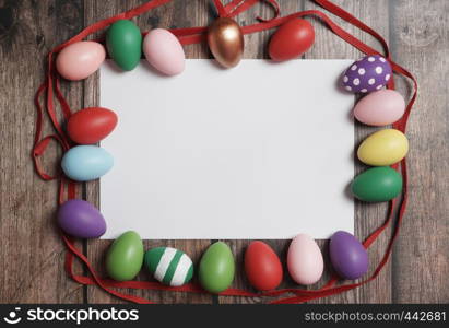 Flat-lay colorful Easter eggs on wooden table copy-space