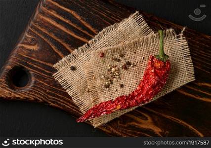 Flat lay composition with dry chili peppers on dark background. Space for text
