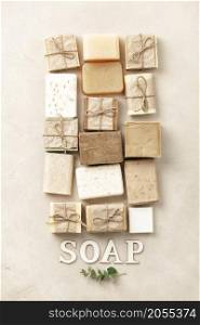 Flat lay composition with Handmade natural eco soap bars and wood letters on beige background. Homemade Soap closeup. Natural Soap making. Soap bars closeup. Spa treatments, skin care concept.. Flat lay composition with handmade soap bars and wood letters on beige background