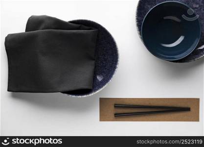 flat lay dark dinnerware with chopsticks
