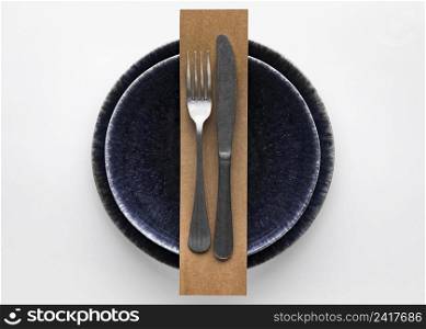 flat lay dark dinnerware with fork knife