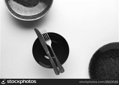 flat lay dark dinnerware with knife fork