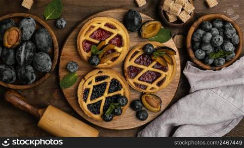 flat lay delicious fruit pies with plums
