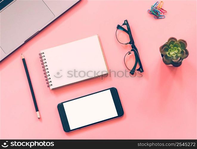 Flat lay design of workspace desk with laptop, blank notebook, smartphone, pencil, stationery with copy space background