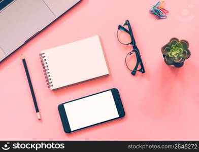 Flat lay design of workspace desk with laptop, blank notebook, smartphone, pencil, stationery with copy space background