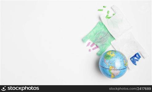 flat lay earth globe with plastic bags copy space