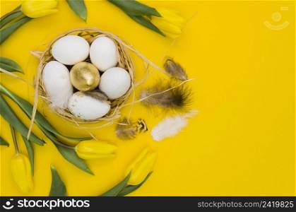 flat lay easter eggs basket with tulips feathers