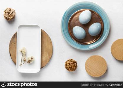 flat lay easter eggs with plates flowers