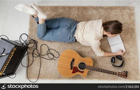 flat lay female musician home writing song with headphones acoustic guitar