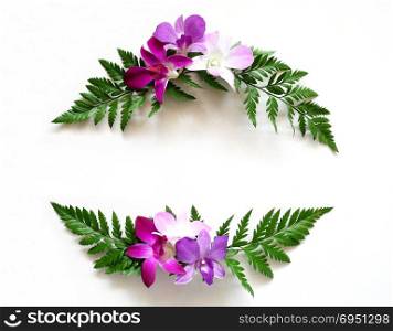 Flat lay frame wreath made of orchids flower and green leaves. Top view, copy space.