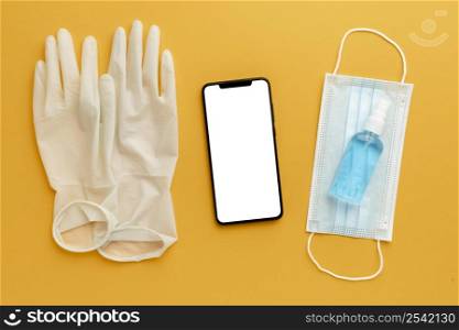 flat lay gloves with smartphone hand sanitizer