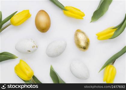 flat lay golden easter eggs with tulips