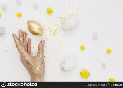 flat lay golden egg easter with glitter dandelions