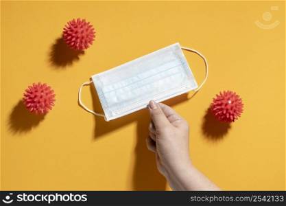 flat lay hand holding medical mask with viruses