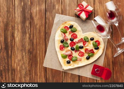 flat lay heart shaped pizza with ring