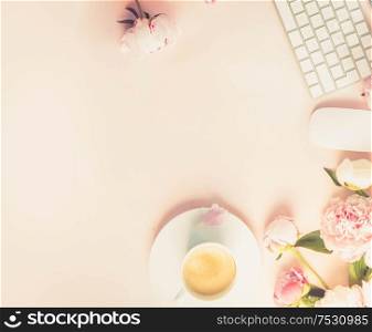 Flat lay home office workspace - modern keyboard with female accessories and fresh peony flowers, copy space on pink desk background, toned. Top view home office workspace