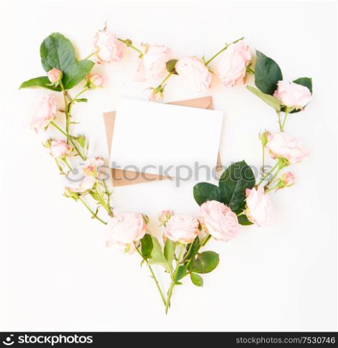 Flat lay home office workspace - notebook with copy space and rose flowers in heart shape. Top view home office workspace