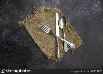 Flat lay image of vintage cutlery on textured rough background