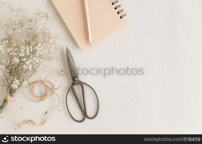 flat lay image with old scissors and notebook on paper background