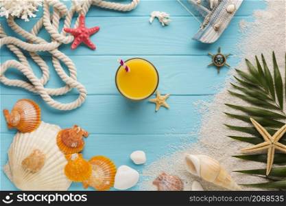 flat lay juice glass surrounded by beach elements